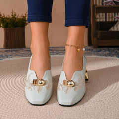 Paire d'escarpins bleus vue de face, broderie claire et boules dorées sur l'empeigne