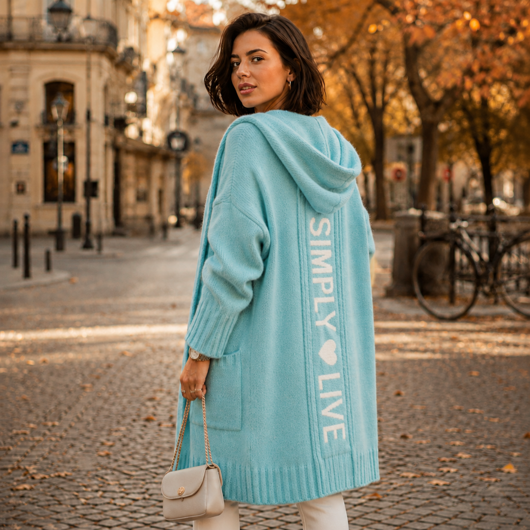 Dos du gilet bleu clair à capuche avec inscription blanche verticale et maille torsadée
