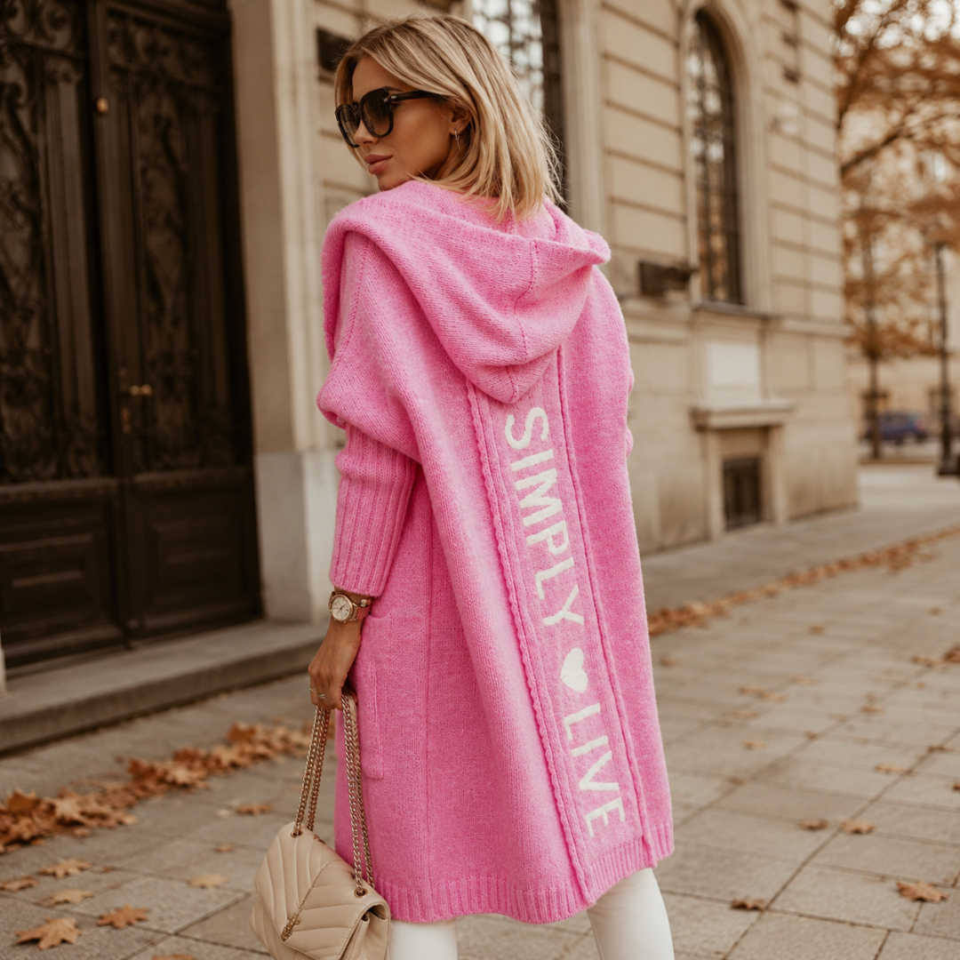 Dos du gilet rose à capuche avec inscription blanche verticale et bas côtelé