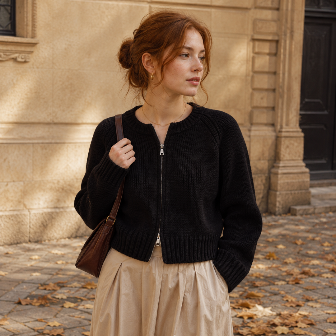 Gilet femme noir en maille zippé, porté avec une jupe beige plissée