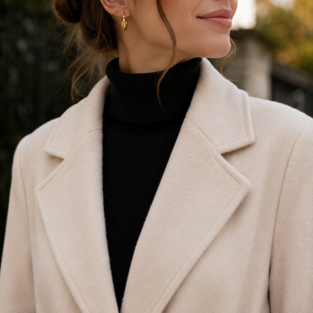 Détail du col tailleur à revers crantés d'un manteau femme beige