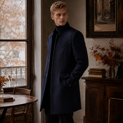 Manteau bleu marine mi-long porté de trois quarts, poche passepoilée et poches à rabat visibles