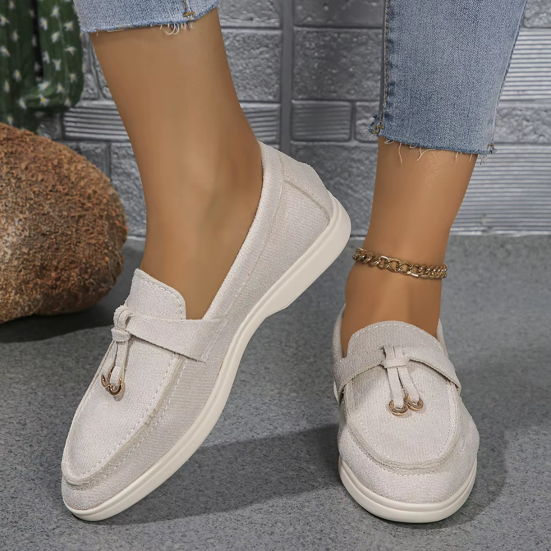 Mocassin femme blanc cassé slip-on avec pompon métal, porté de côté