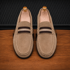 Mocassins taupe posés sur surface en bois, vue légèrement de haut