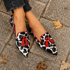 Paire de mocassins plats imprimé vache à pompons rouges vue de dessus