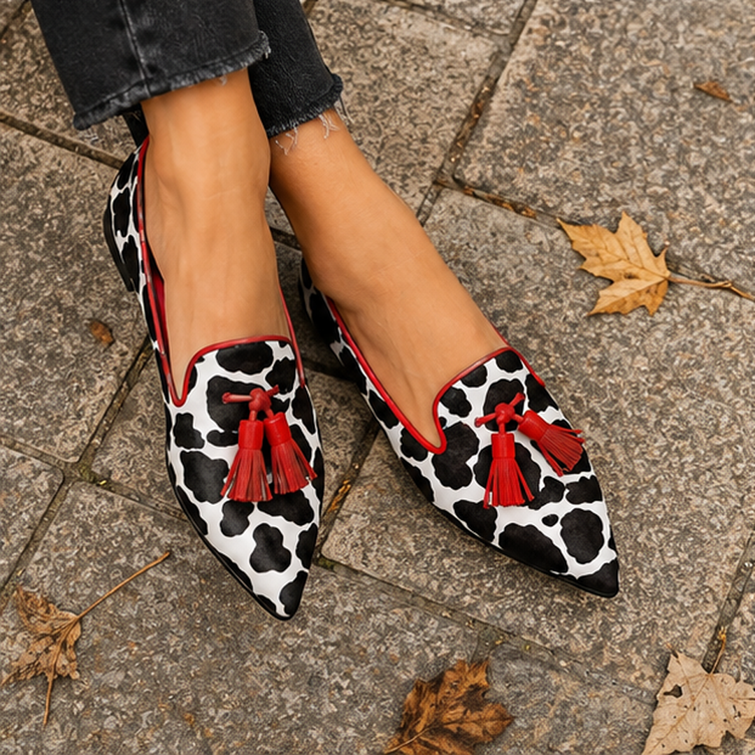 Paire de mocassins plats imprimé vache à pompons rouges vue de dessus