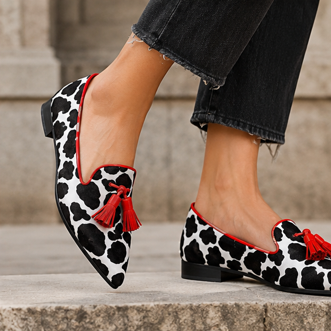 Mocassins imprimé vache à bout pointu et pompons rouges, vue de profil