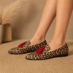 Mocassins femme léopard portés sur tapis tressé, encoche latérale visible