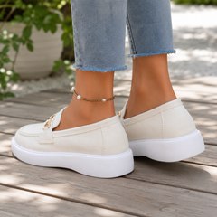 Mocassins femme blancs vus de dos, arrière souple et plateforme blanche sur terrasse en bois