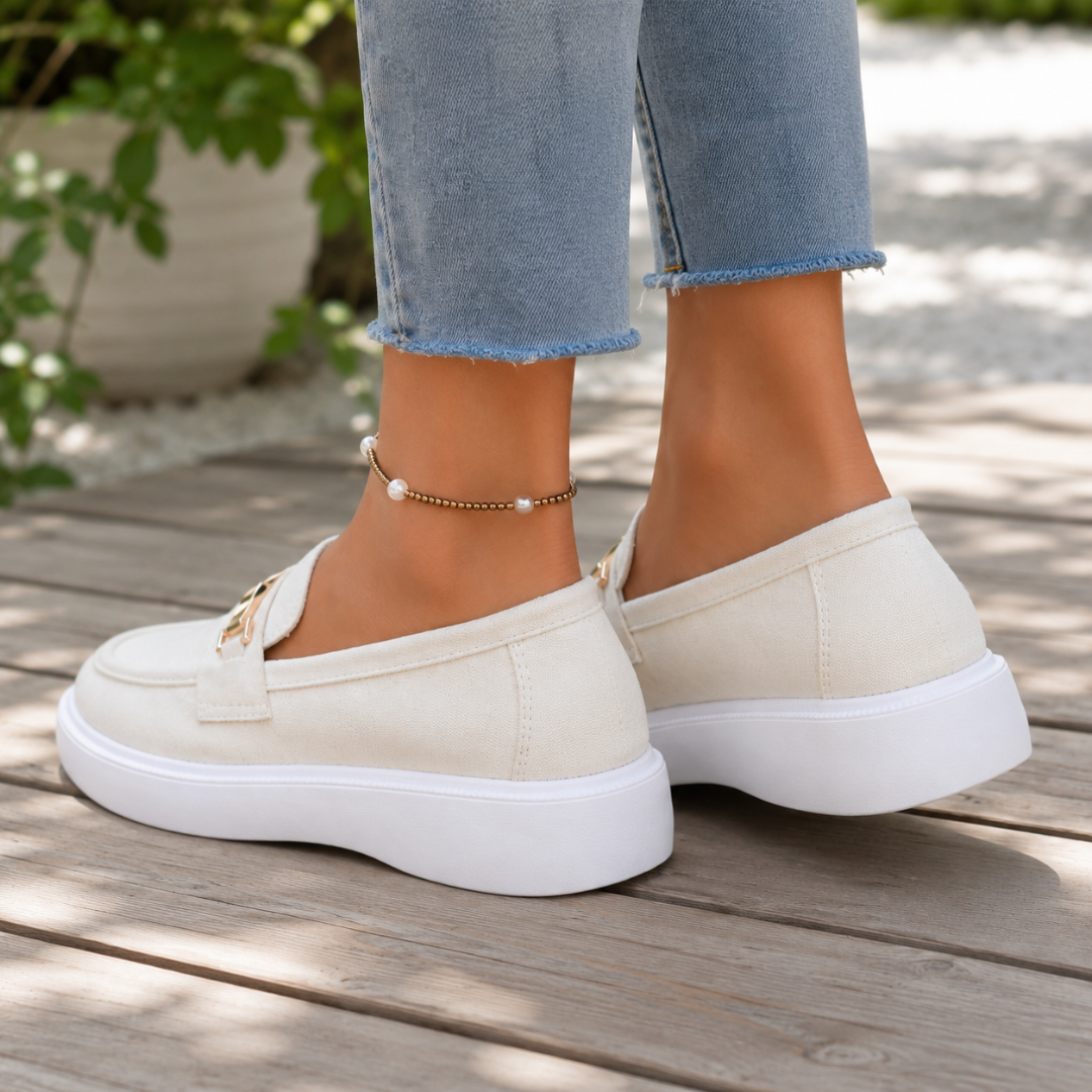 Mocassins femme blancs vus de dos, arrière souple et plateforme blanche sur terrasse en bois