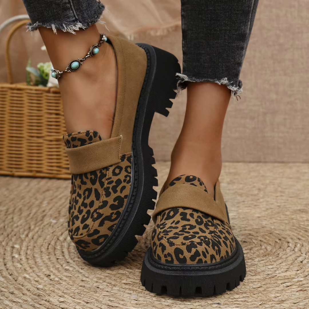 Mocassins femme marron à imprimé léopard avec semelle crantée noire portés au pied