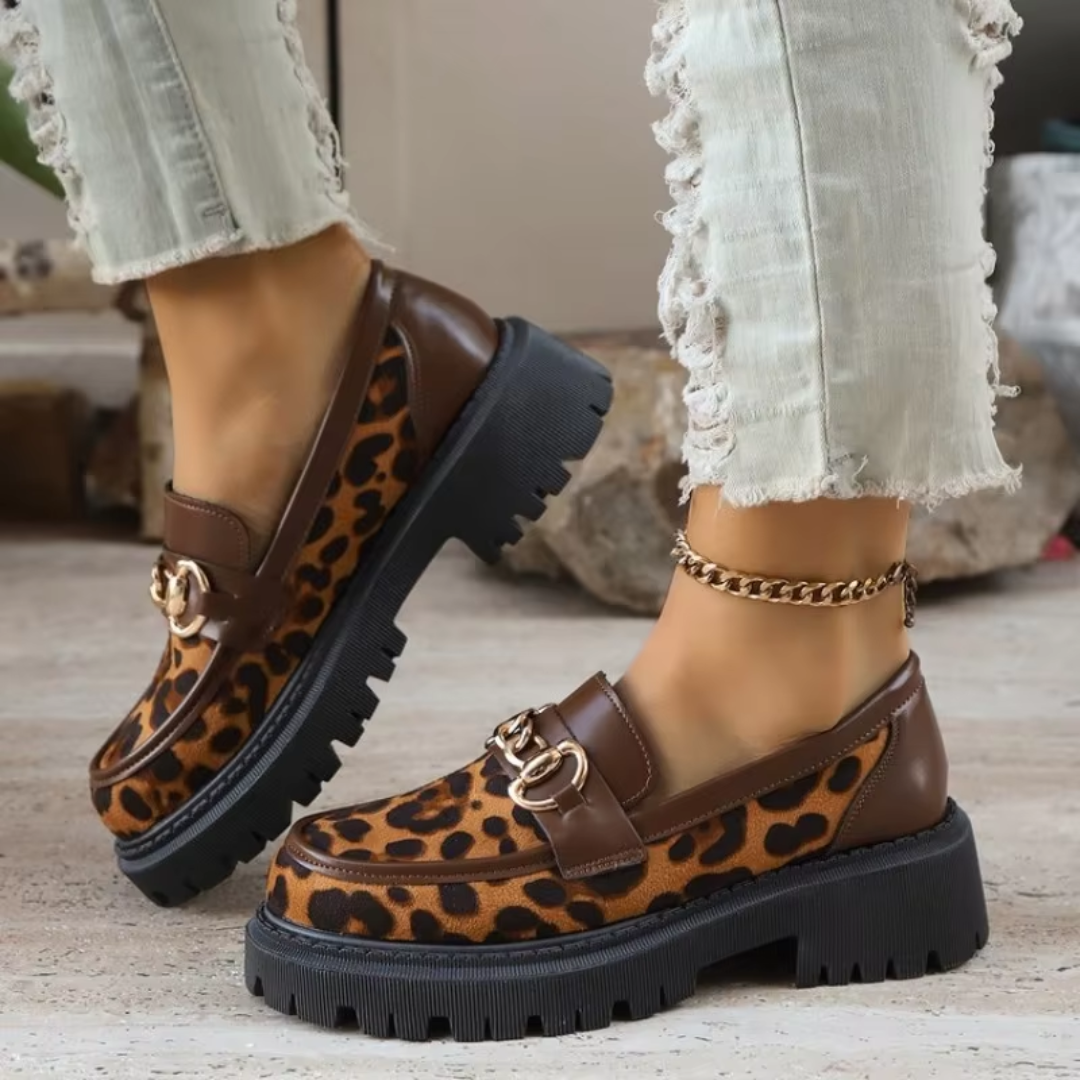 Mocassins léopard marron portés avec un pantalon clair, détail chaîne doré sur le dessus