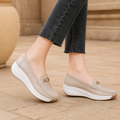 Mocassins beige portés de profil, plateforme nervurée et talon compensé arrondi