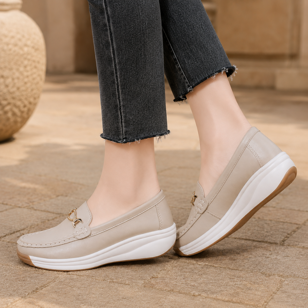 Paire de mocassins beige vue de trois quarts, surpiqûres contrastées sur le bout arrondi