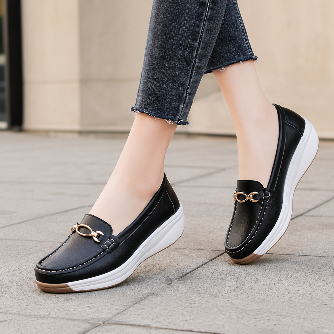 Mocassins noirs femme sur semelle compensée blanche, détail doré sur l'avant