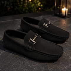 Mocassins noirs éclairés par une lanterne, mors métallique clair posé sur la patte