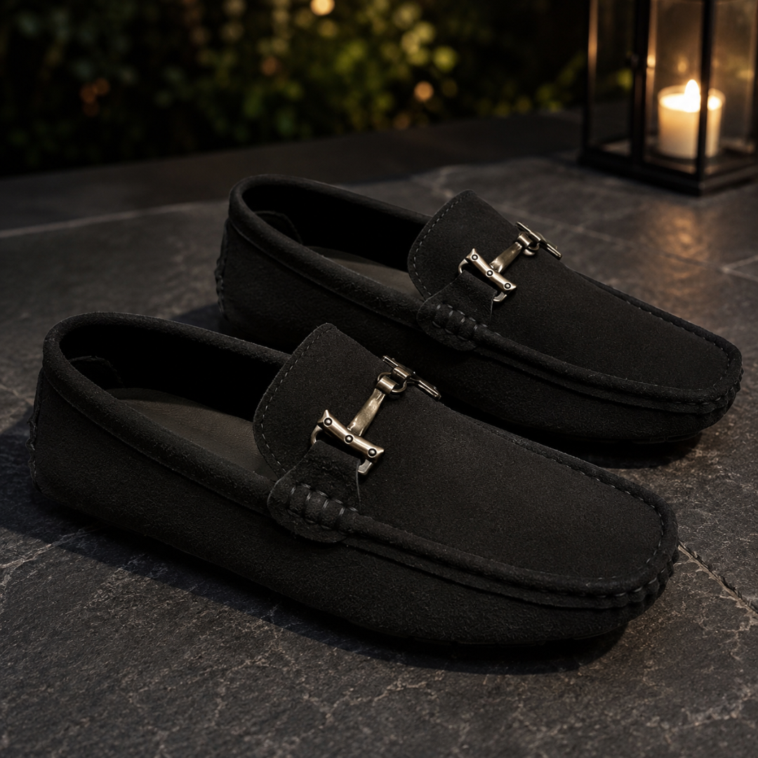 Mocassins noirs éclairés par une lanterne, mors métallique clair posé sur la patte