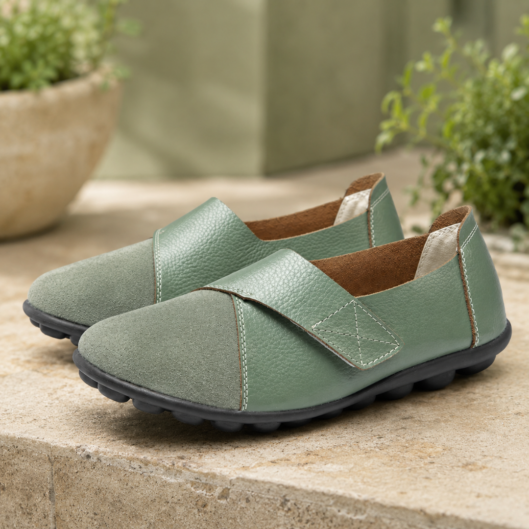 Mocassins femme vert amande, surpiqûres claires et intérieur camel, sur marche en pierre