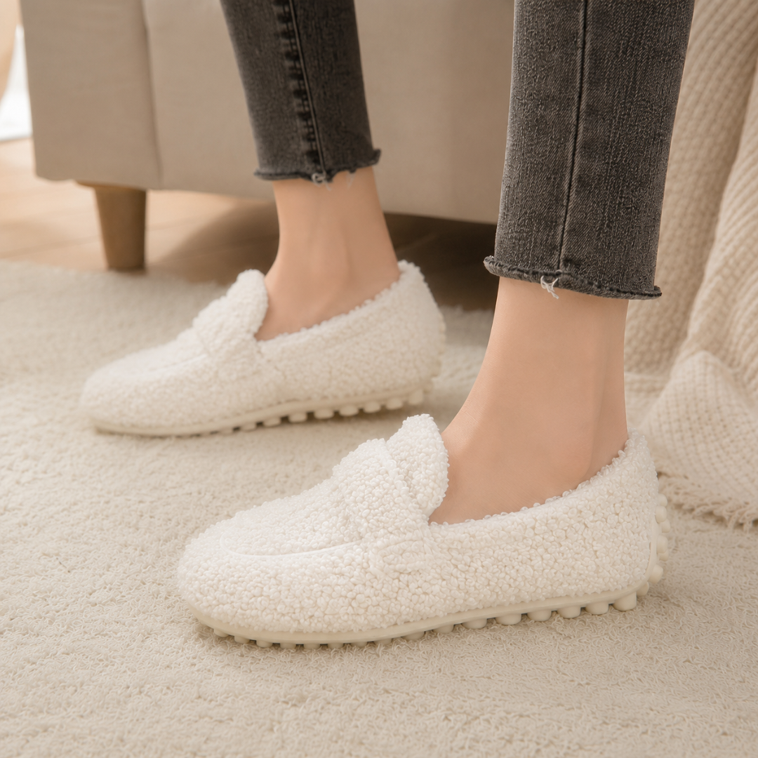 Mocassins blancs plats avec semelle crantée à picots, portés avec un pantalon gris