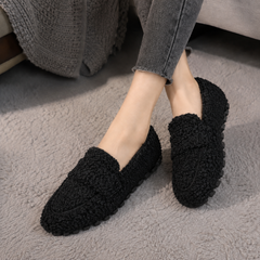 Mocassins noirs à surface bouclée et semelle crantée, portés avec un pantalon gris
