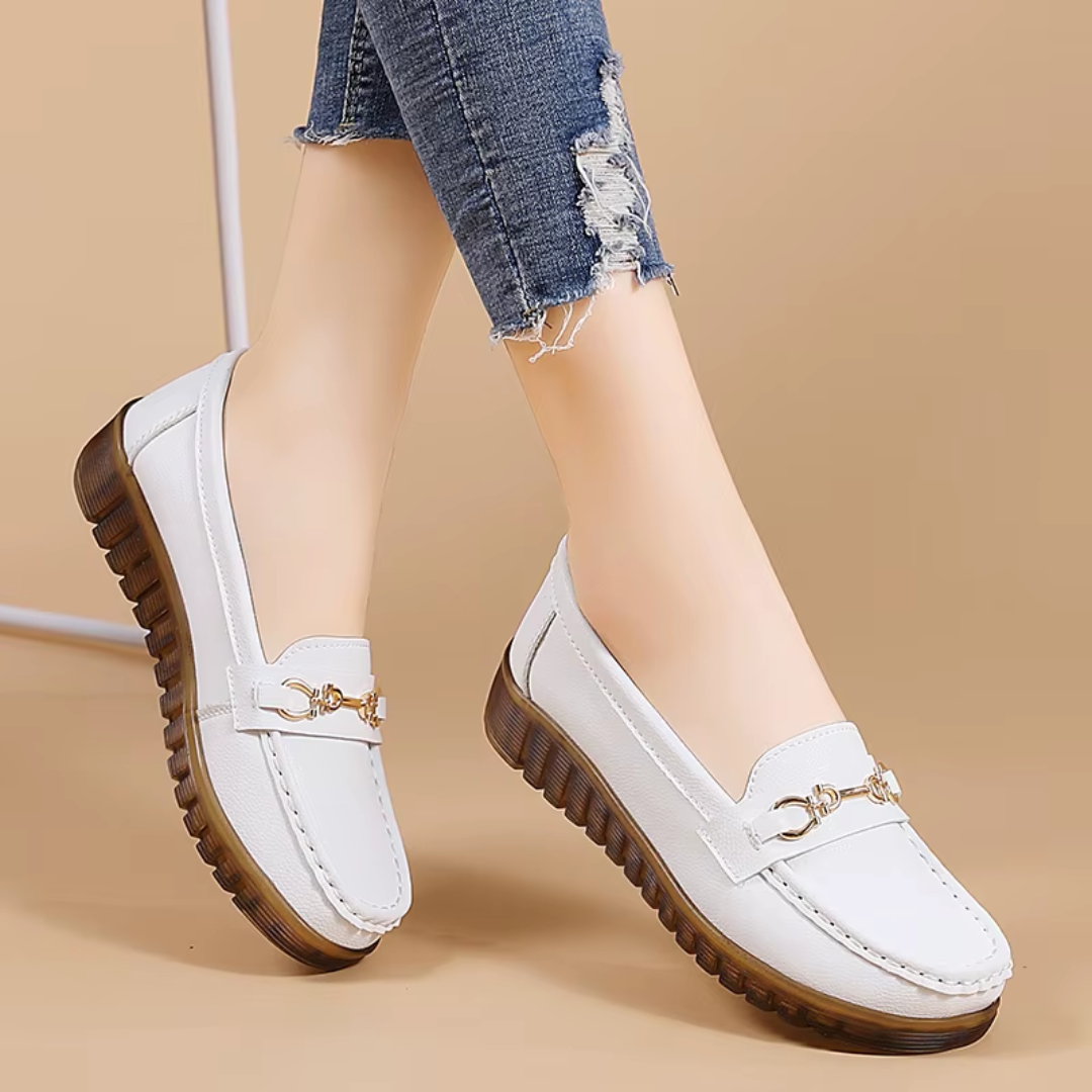 Mocassins blancs portés, vue latérale sur fond beige