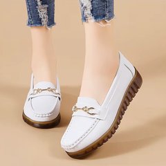 Mocassins blancs portés avec jean, vue de dessus légèrement inclinée