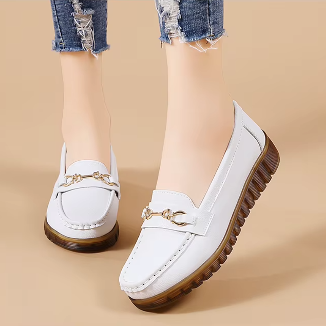 Mocassins blancs portés avec jean, vue de dessus légèrement inclinée