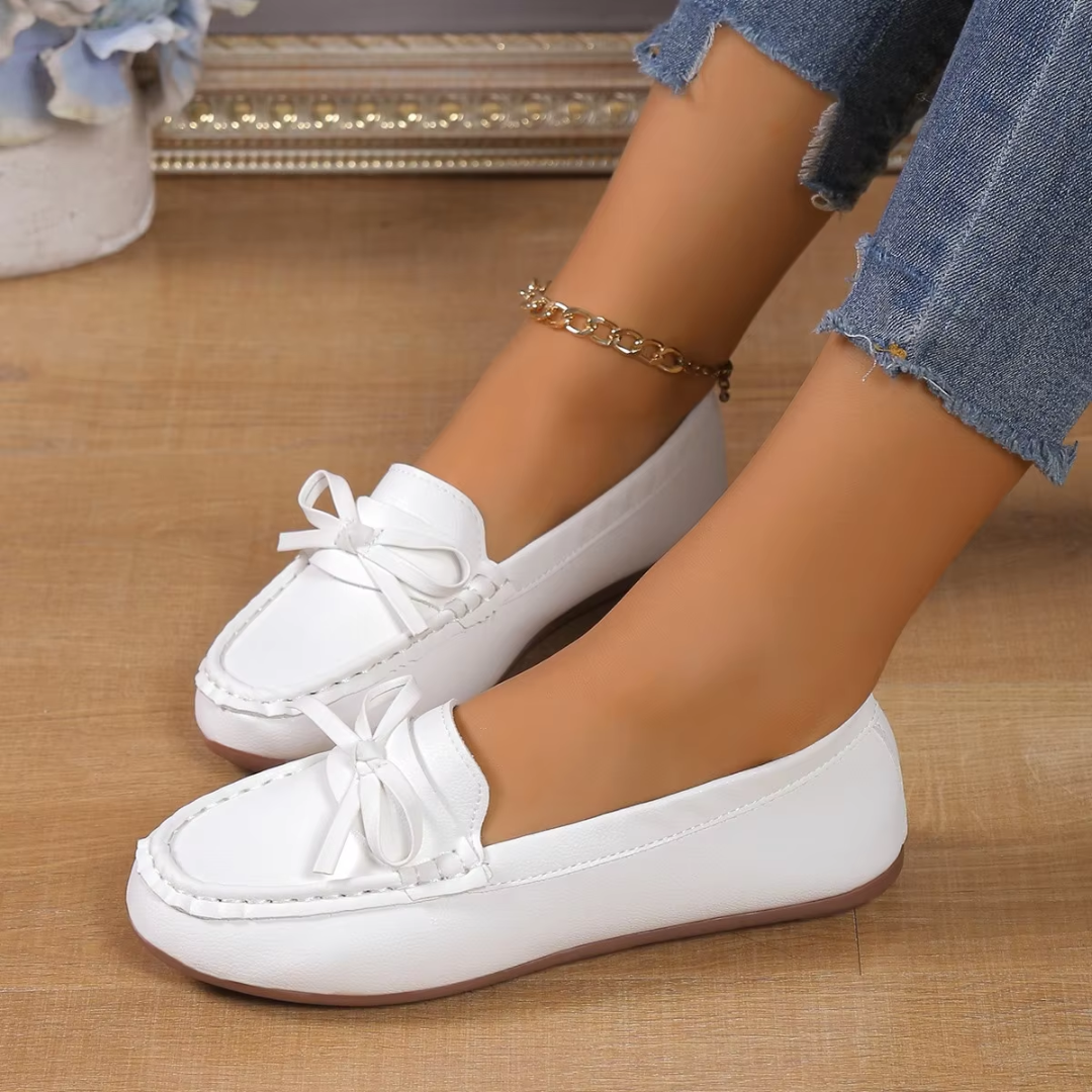 Mocassins blancs à enfiler pour femme, nœud sur le dessus et semelle plate, vue de profil