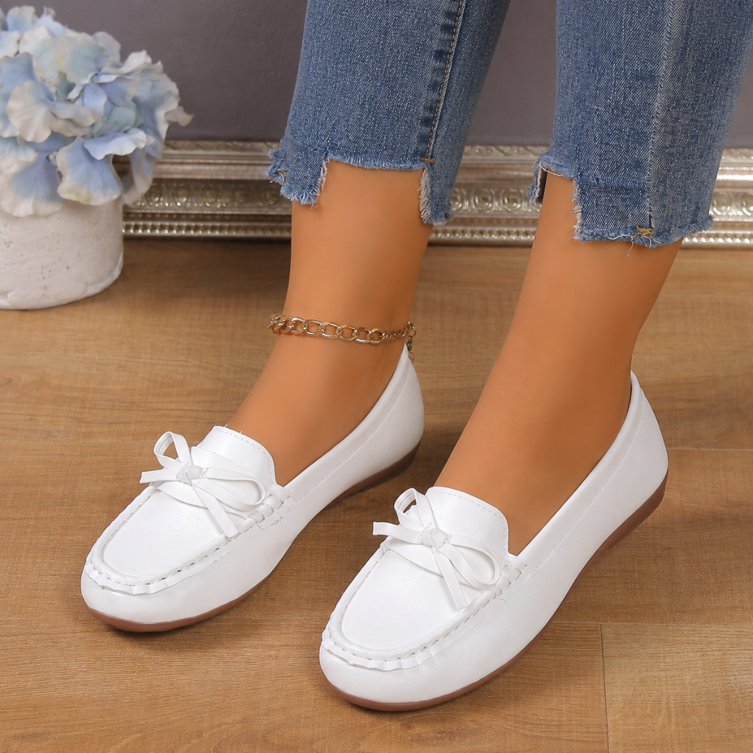 Mocassins plats blancs pour femme vus de face, petit nœud décoratif sur le dessus du pied
