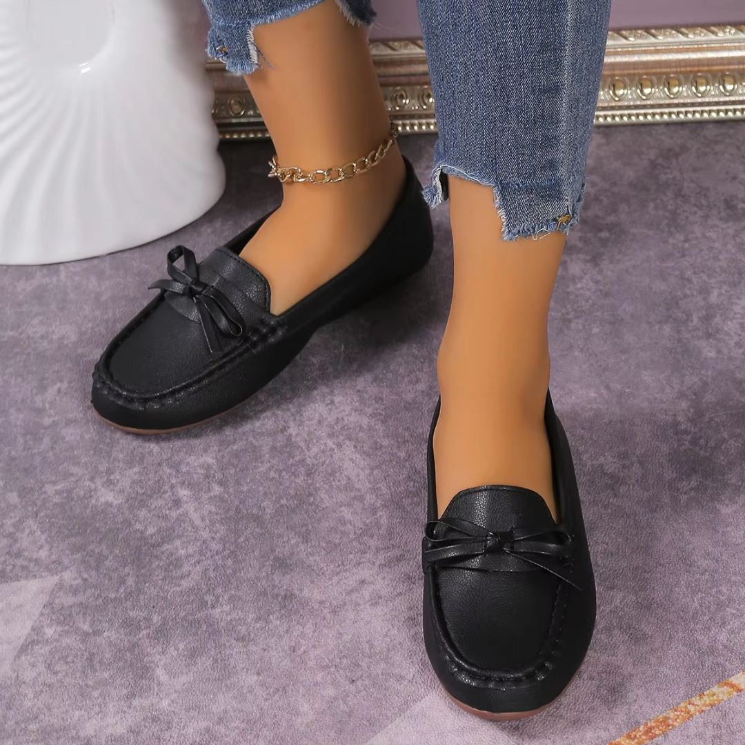 Mocassins noirs plats pour femme avec nœud fin et surpiqûres apparentes sur le pourtour