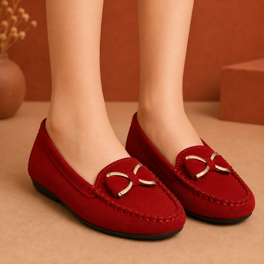 Mocassins rouges plats vus de face, nœud doré centré et fine bordure surpiquée
