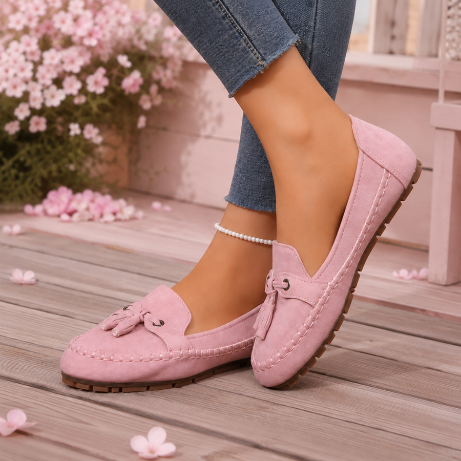 Mocassins plats rose vus de côté, semelle crantée marron et bout arrondi surpiqué