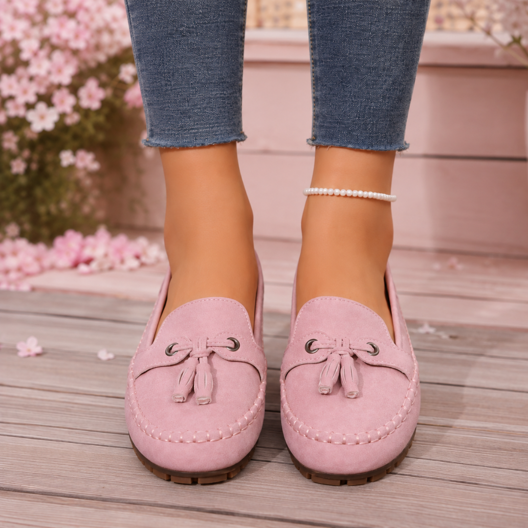 Mocassins femme rose de face, pompons et œillets métalliques sur le dessus du pied