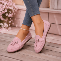 Mocassins plats rose portés en marche, ouverture enveloppante et semelle souple visible