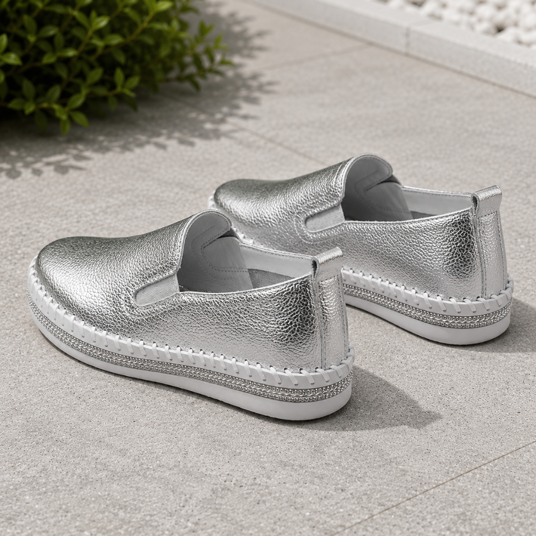 Mocassins argent vus de dos avec languette au talon et semelle épaisse blanche
