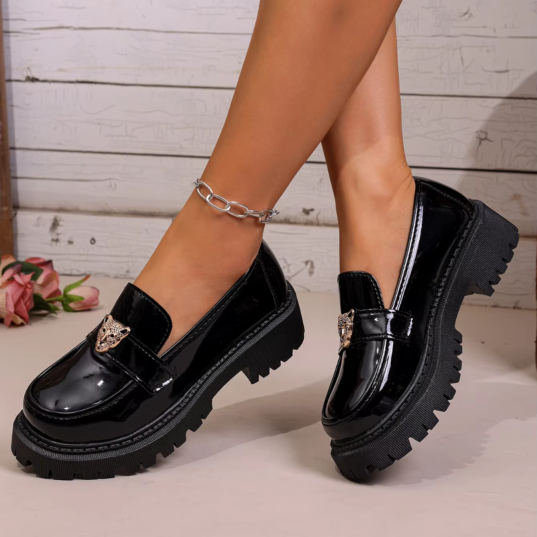 Paire de mocassins noirs à enfiler avec bride et ornement métallique doré sur le dessus