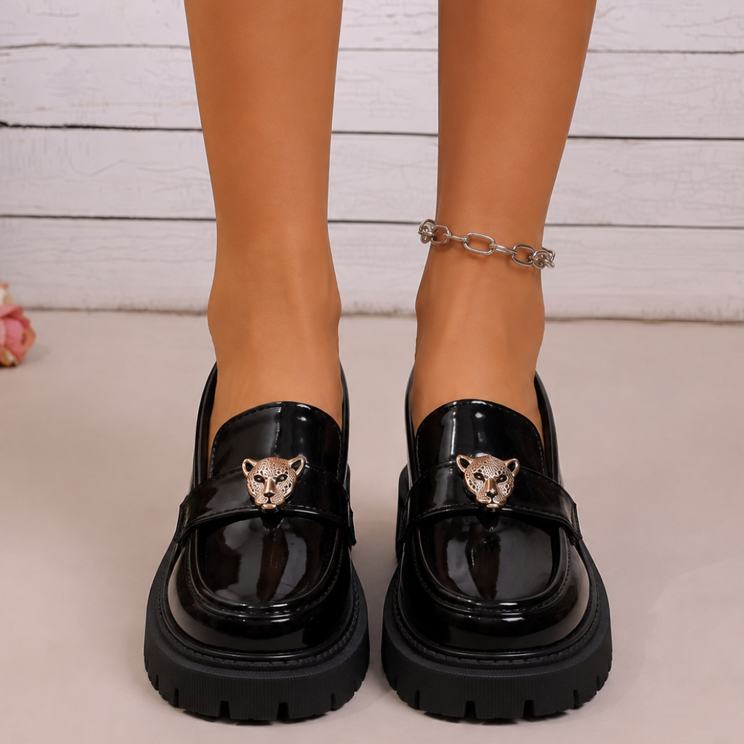 Mocassins noirs vus de face, deux têtes de panthère dorées sur les brides
