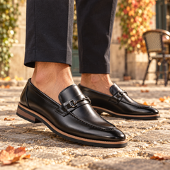 Mocassins homme noirs à enfiler avec mors argenté, portés avec un pantalon foncé