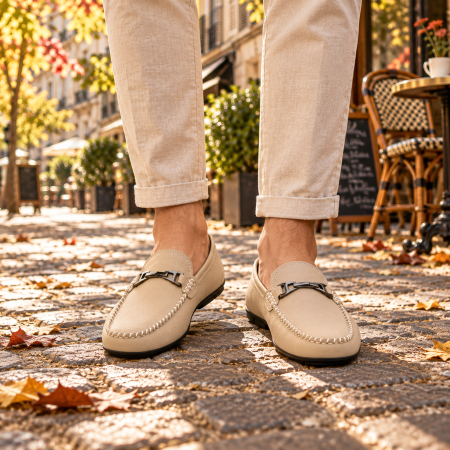 Mocassins homme blancs à mors métallique portés sur pavés, couture tressée visible