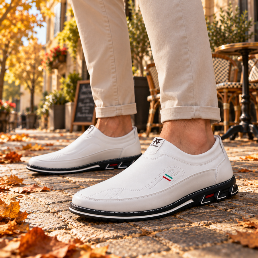 Mocassins blancs homme portés de profil, empeigne surpiquée et écusson tricolore sur le côté