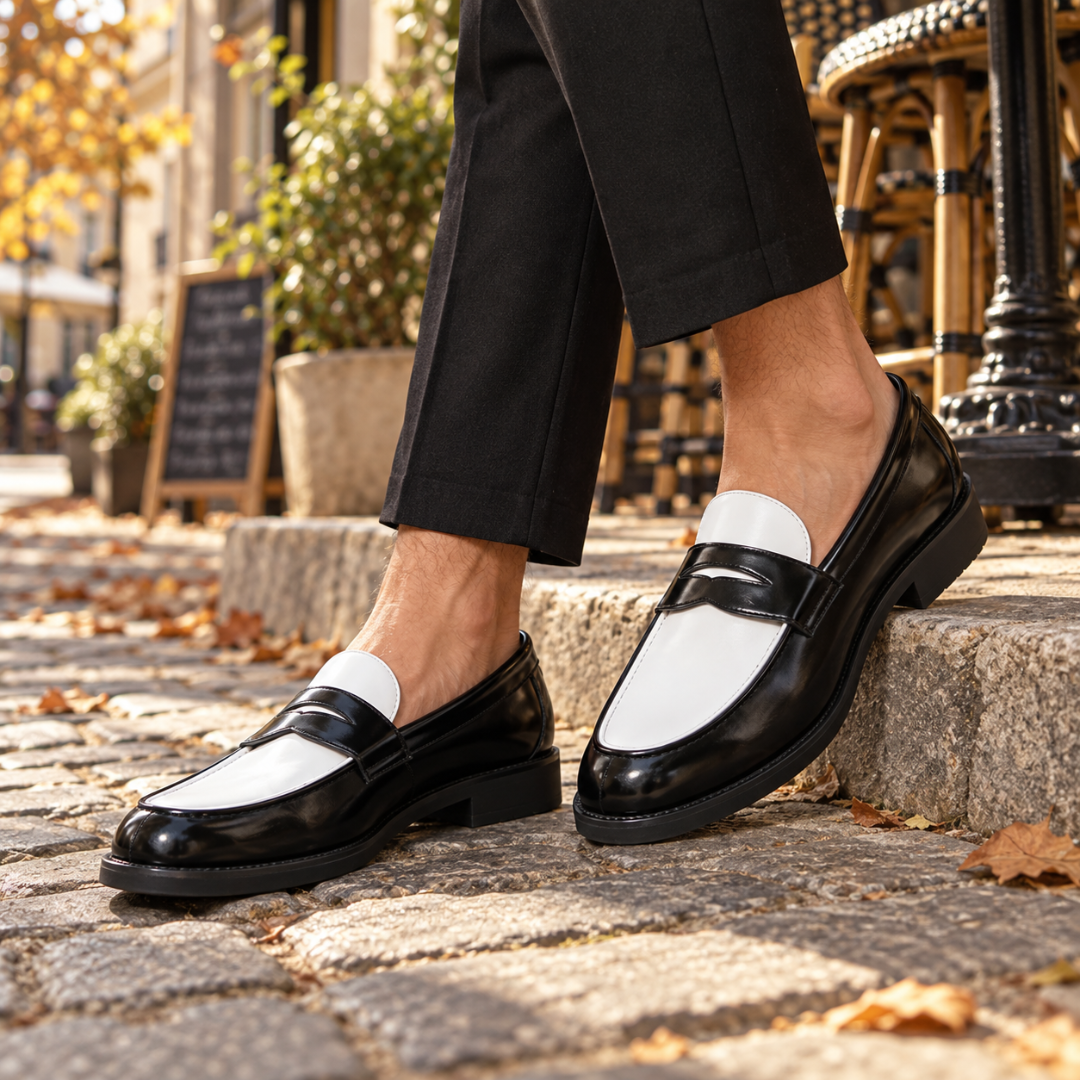 Paire de mocassins noirs et blancs à enfiler, bout arrondi sur pavés ensoleillés