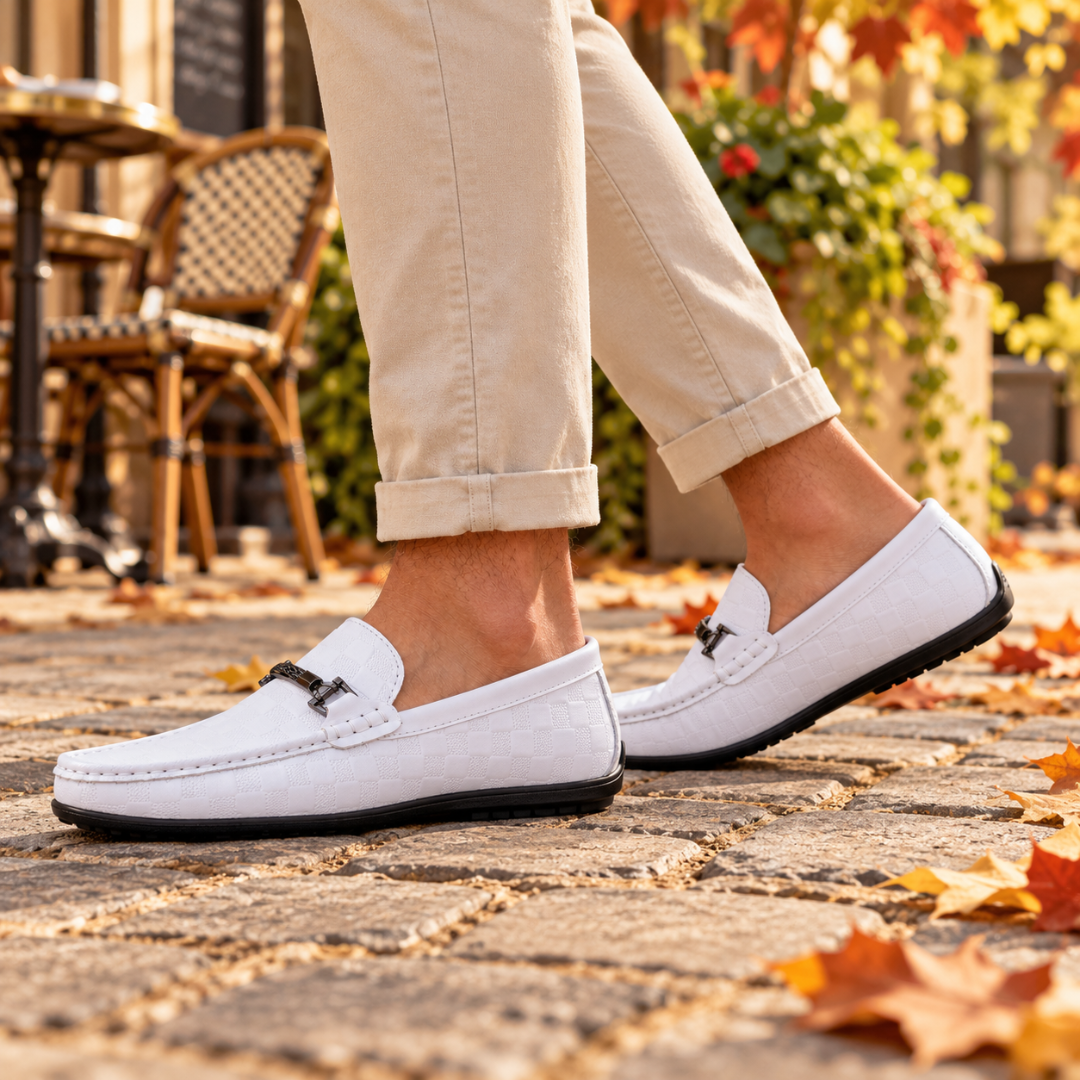 Paire de mocassins blancs à enfiler avec mors métallique foncé sur le dessus du pied