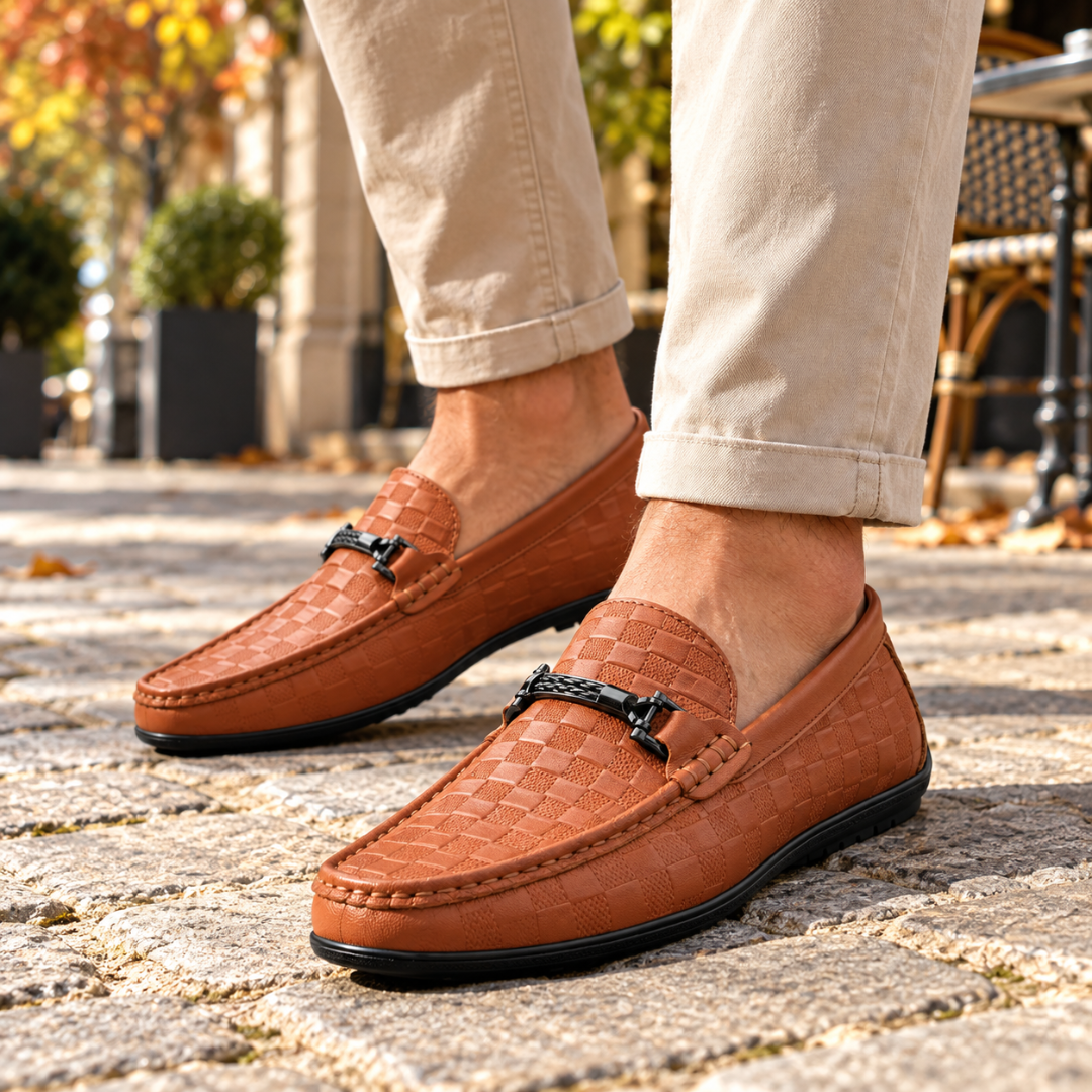 Mocassins homme marron à damier gravé et mors métallique, portés sans chaussettes