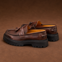Mocassins marron foncé vus de dos, talon plat et intérieur jaune apparent