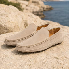 Paire de mocassins homme beiges à surpiqûres claires posée sur un rocher