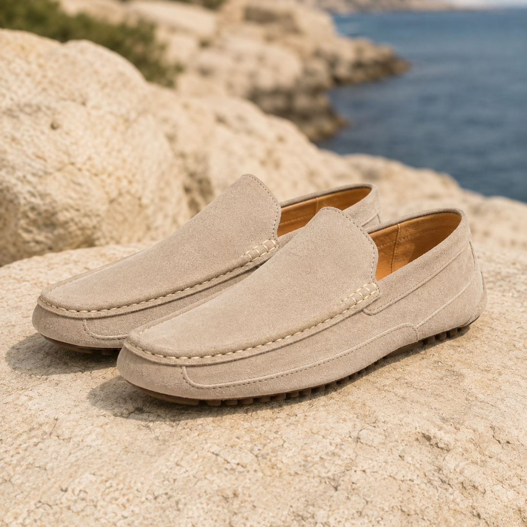 Paire de mocassins homme beiges à surpiqûres claires posée sur un rocher
