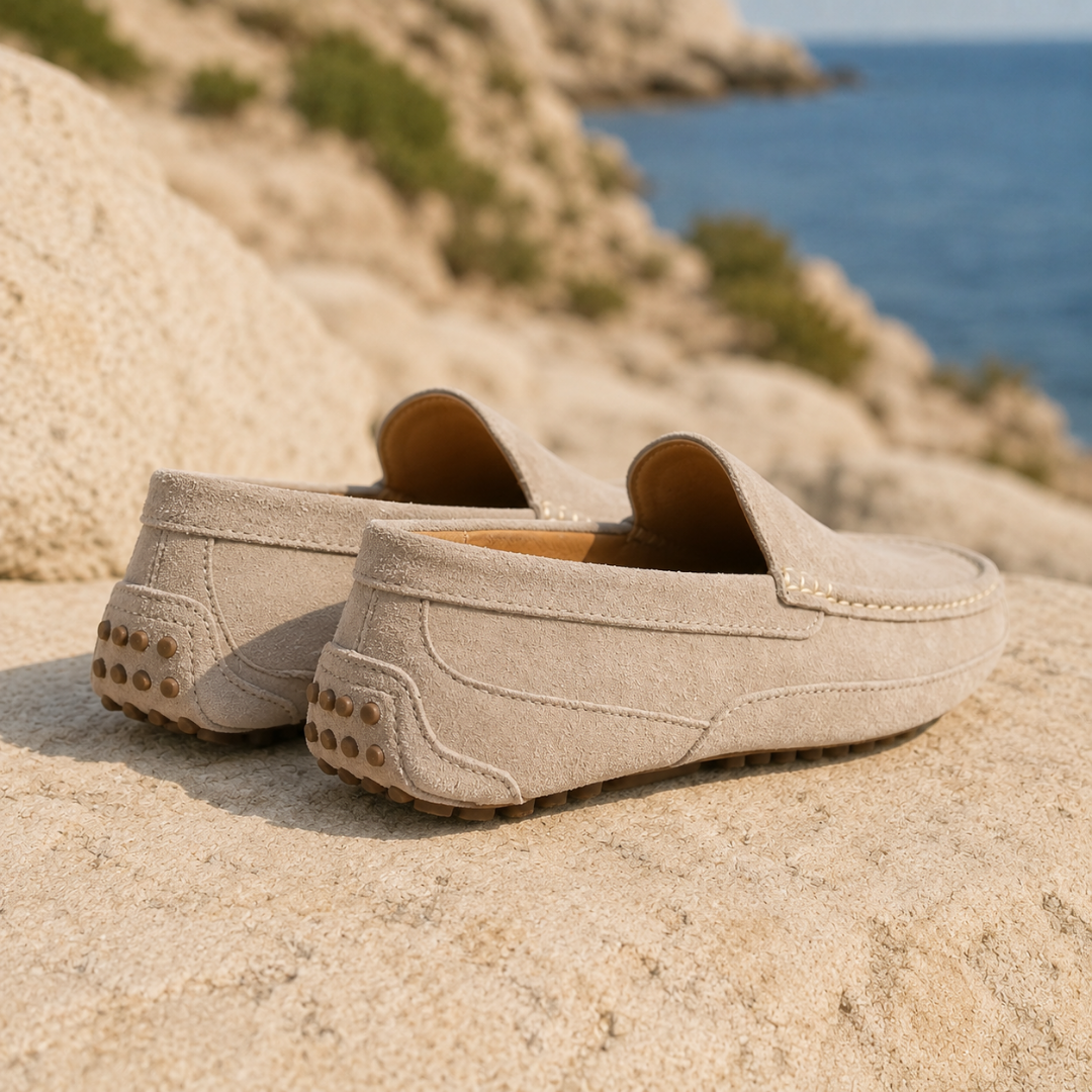 Mocassins homme beiges vus de dos, semelle à picots visible sous le talon