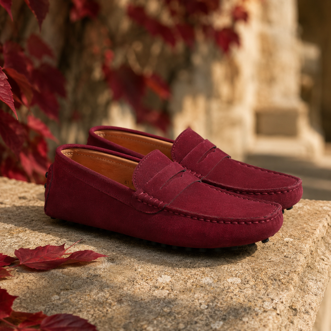 Mocassins homme bordeaux posés sur un muret, bout arrondi et surpiqûres apparentes