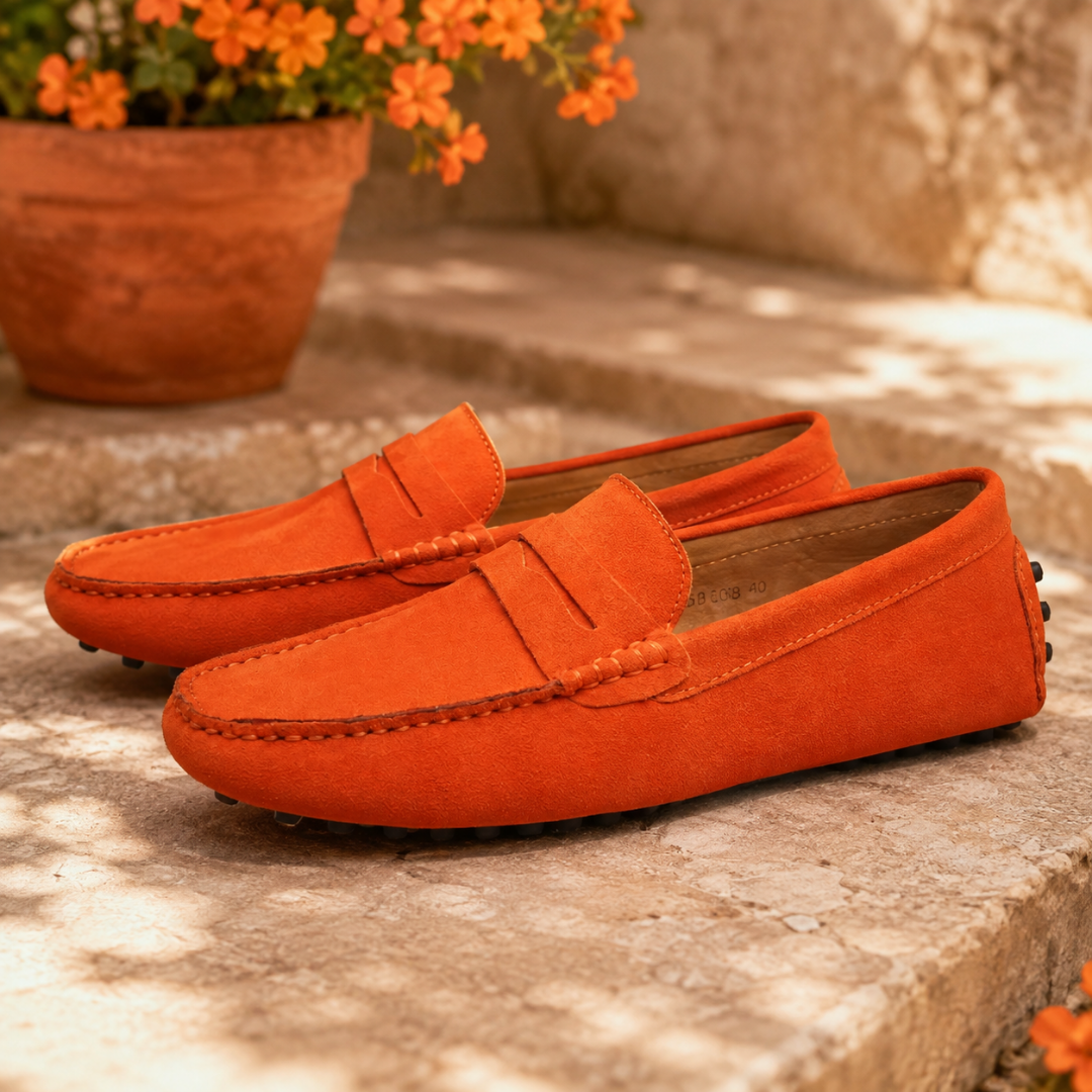 Mocassins homme orange sur une marche en pierre, semelle à picots noirs visible
