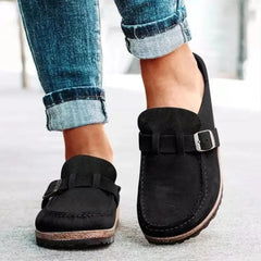 Mules femme noires en suédine avec boucle, portées avec jean foncé